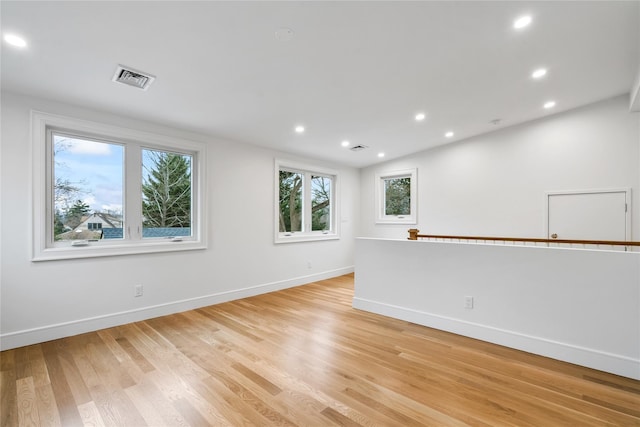 spare room with lofted ceiling and light hardwood / wood-style floors