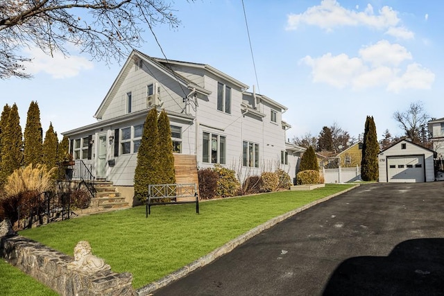 view of front of house featuring an outbuilding, a garage, and a front lawn