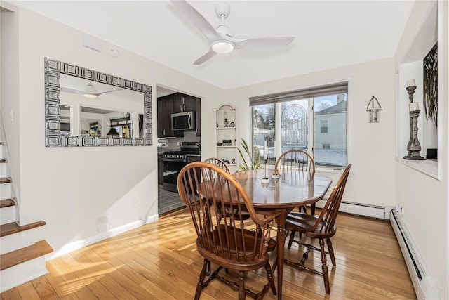 dining area featuring baseboard heating, ceiling fan, and light wood-type flooring