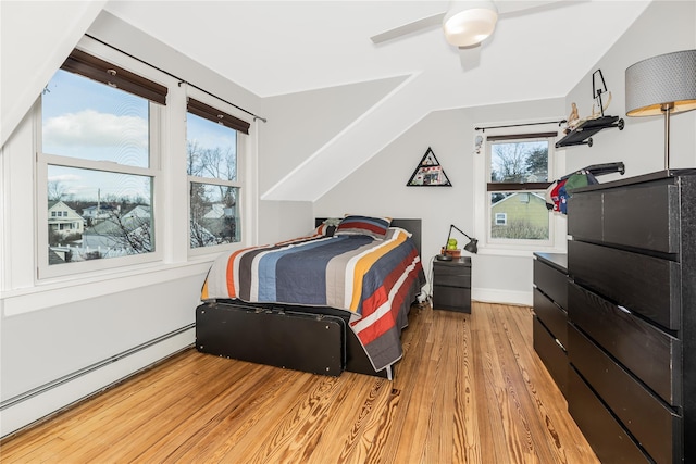 bedroom featuring ceiling fan, vaulted ceiling, baseboard heating, and light hardwood / wood-style flooring