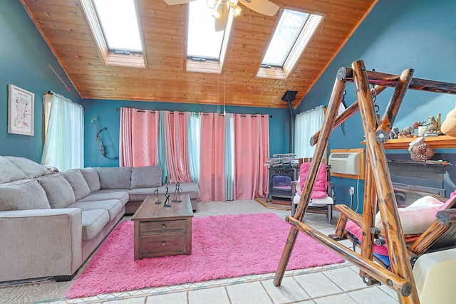living room with a ceiling fan, wooden ceiling, a wood stove, and a healthy amount of sunlight