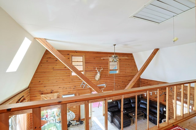corridor with a skylight, visible vents, wooden walls, and high vaulted ceiling
