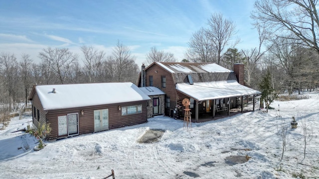 view of front of house with a chimney and a gambrel roof