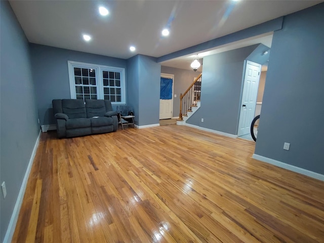 unfurnished living room with a baseboard heating unit and light wood-type flooring