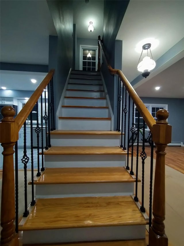 stairway with a baseboard heating unit and a water view