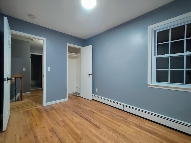 unfurnished bedroom featuring a baseboard radiator and light hardwood / wood-style floors