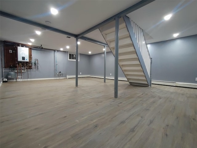 basement featuring hardwood / wood-style flooring and a baseboard heating unit