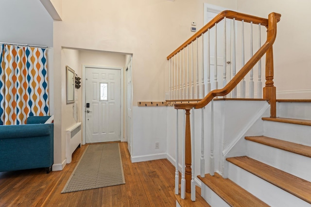 entrance foyer featuring dark wood-type flooring and radiator heating unit