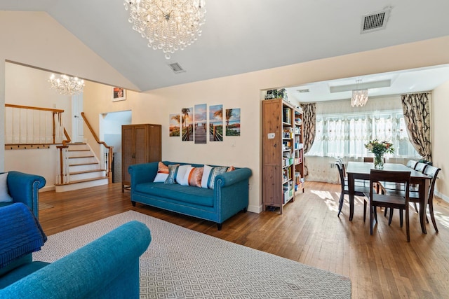 living room featuring an inviting chandelier, hardwood / wood-style floors, and lofted ceiling