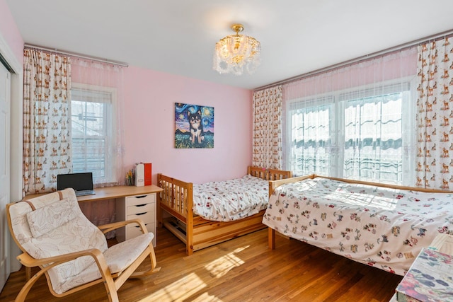 bedroom featuring hardwood / wood-style floors and a chandelier