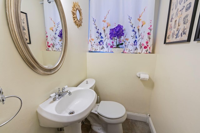 bathroom with toilet, tile patterned flooring, and sink