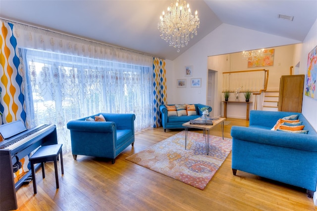 living area featuring high vaulted ceiling, visible vents, a chandelier, and wood finished floors