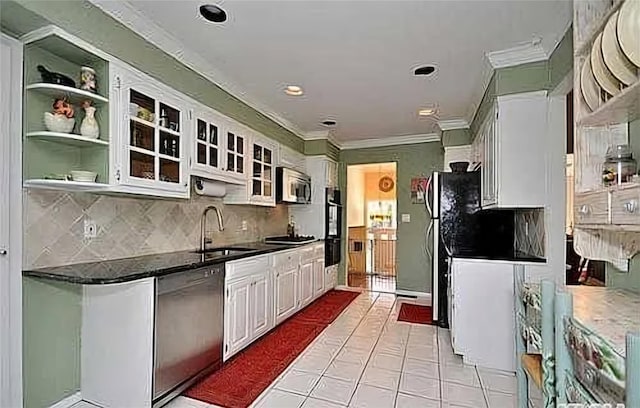 kitchen featuring appliances with stainless steel finishes, tasteful backsplash, white cabinetry, sink, and ornamental molding