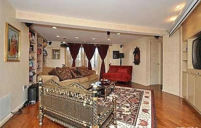 living room featuring dark wood-type flooring and beam ceiling