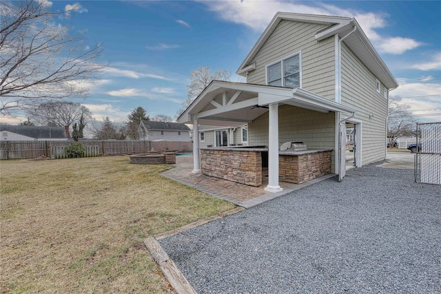 view of property exterior with an outdoor kitchen, a yard, exterior bar, and a patio