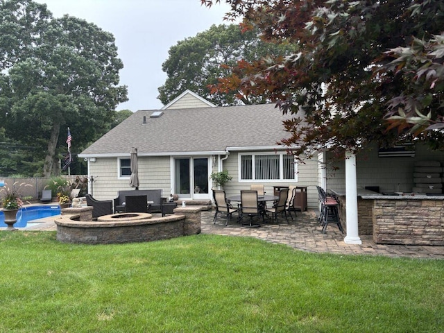 back of house featuring a yard, a fenced in pool, an outdoor bar, and a patio