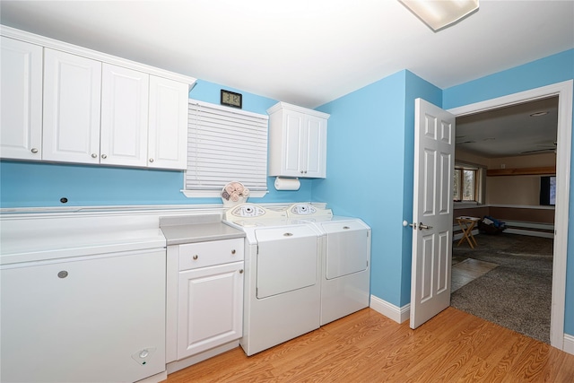 washroom with cabinets, washer and clothes dryer, and light hardwood / wood-style flooring