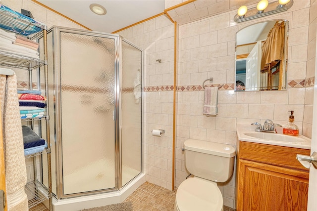 bathroom featuring vanity, tile walls, an enclosed shower, and toilet