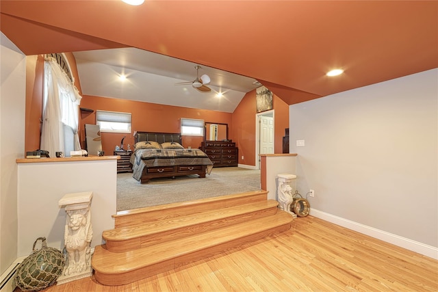 bedroom featuring ceiling fan, lofted ceiling, light wood-type flooring, and a baseboard radiator