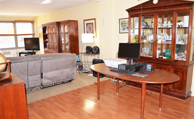 home office with light hardwood / wood-style flooring