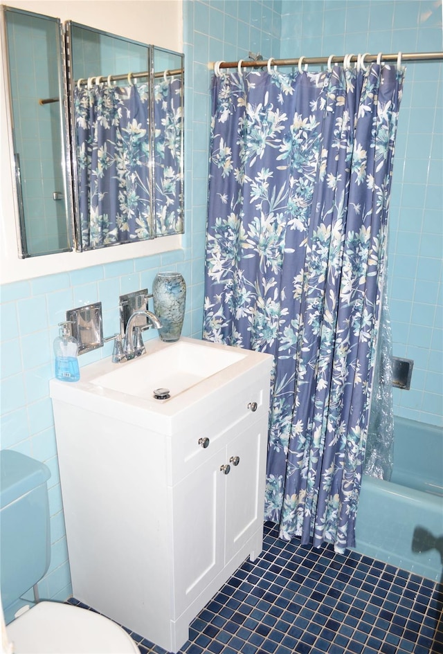 full bathroom with toilet, tile walls, vanity, shower / bath combo, and decorative backsplash