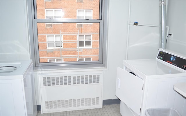 laundry area featuring washer / clothes dryer, light tile patterned floors, and radiator