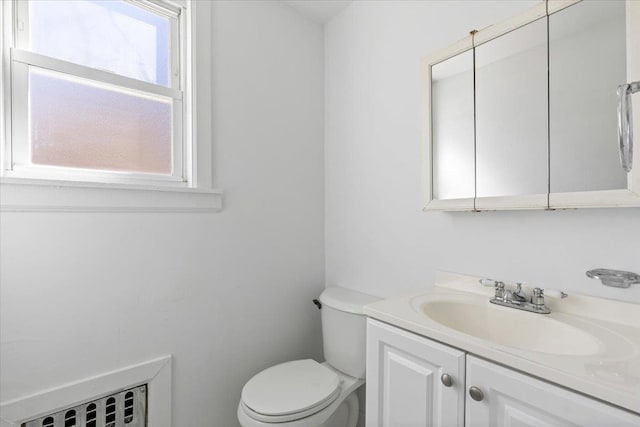 bathroom featuring toilet, vanity, and radiator