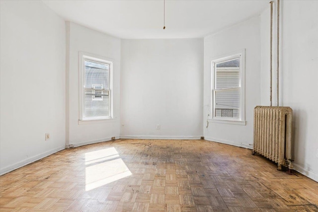 spare room with radiator and baseboards