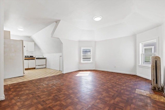 bonus room featuring baseboards, vaulted ceiling, and a sink