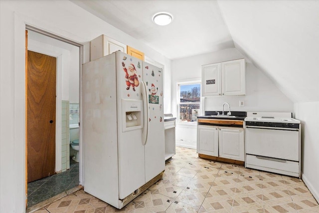 kitchen featuring lofted ceiling, white appliances, white cabinets, and a sink