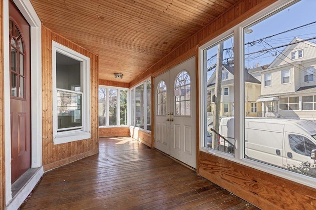 unfurnished sunroom with a residential view and wood ceiling