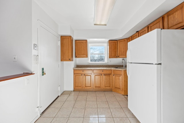 kitchen featuring sink, light tile patterned flooring, and white refrigerator