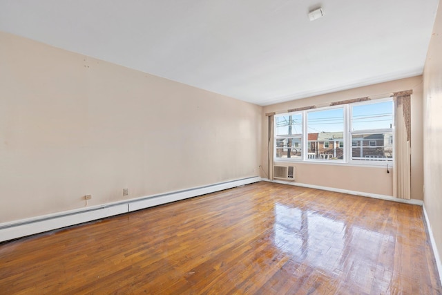 spare room with hardwood / wood-style flooring, a baseboard heating unit, and a wall mounted air conditioner