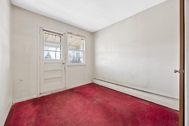 carpeted empty room featuring a baseboard radiator