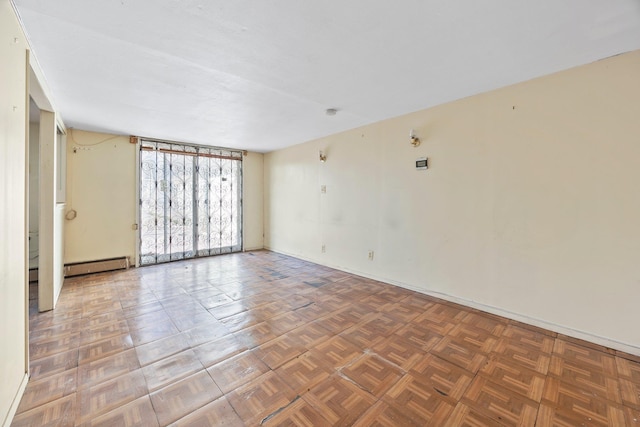 unfurnished room with a baseboard heating unit and parquet flooring