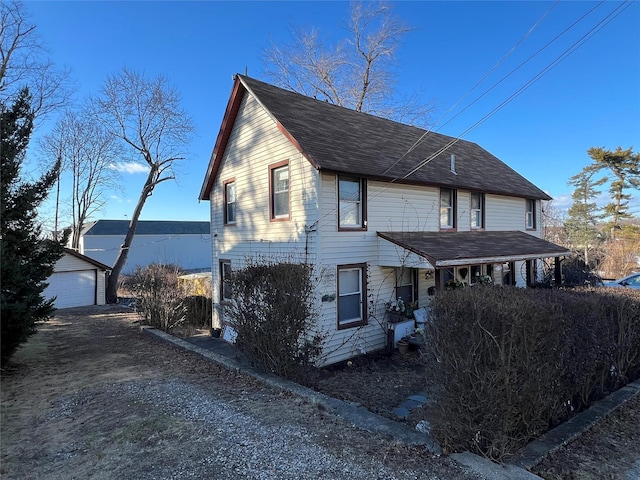 view of front of house with a garage and an outbuilding