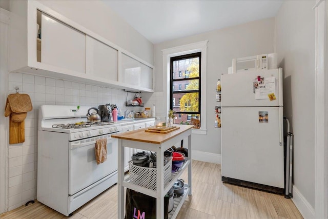 kitchen with white cabinetry, white appliances, and decorative backsplash