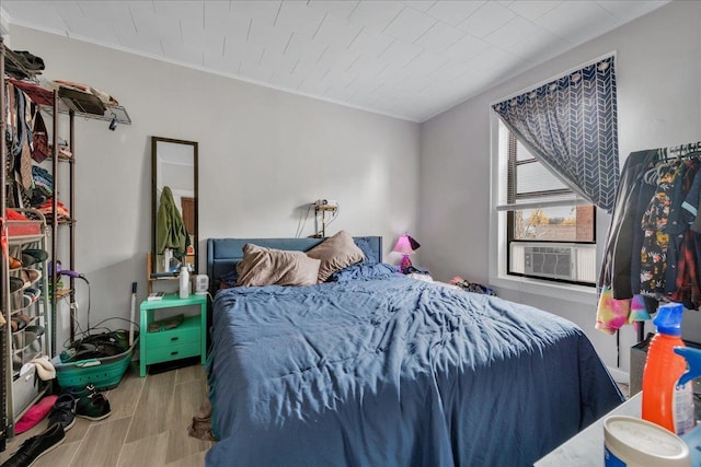 bedroom featuring ornamental molding and light hardwood / wood-style flooring