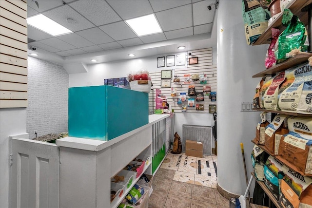 misc room with a paneled ceiling and tile patterned floors