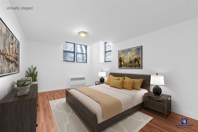 bedroom with wood-type flooring and radiator