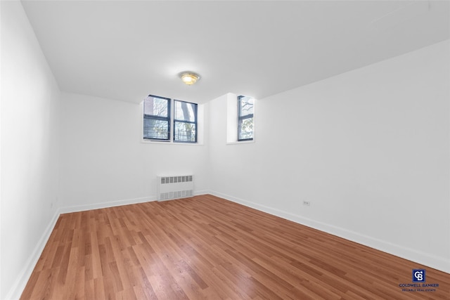 unfurnished room featuring radiator and light hardwood / wood-style floors