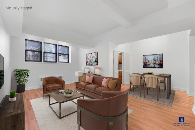 living room with beamed ceiling and light wood-type flooring