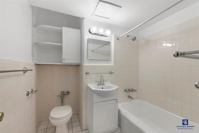 full bathroom featuring tile patterned flooring, tile walls, vanity, toilet, and tiled shower / bath