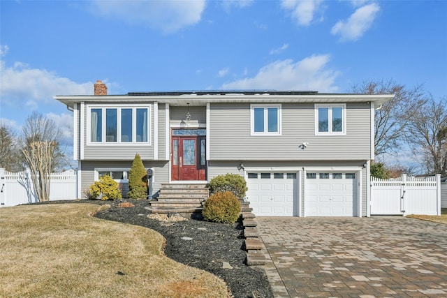 bi-level home with a garage and a front yard