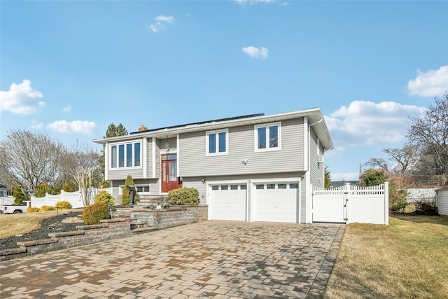 bi-level home with a garage and a front lawn