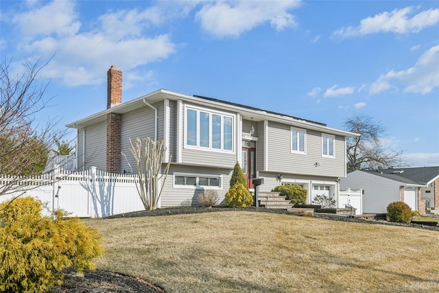 raised ranch with a garage and a front yard