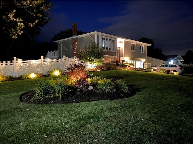 view of front facade with a yard and a garage