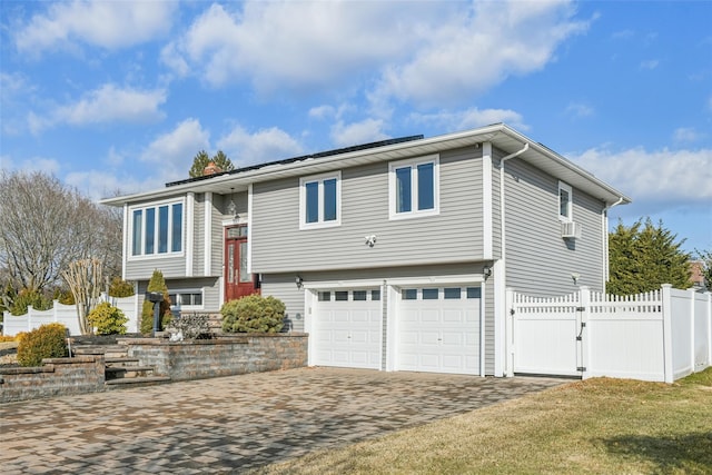 bi-level home with a garage and a front lawn