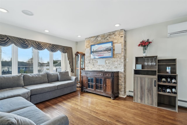 living room featuring a baseboard radiator, wood-type flooring, and a wall unit AC