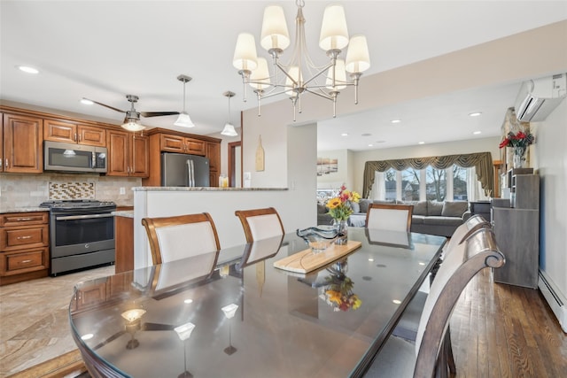 dining area featuring ceiling fan with notable chandelier, a wall mounted AC, and dark hardwood / wood-style flooring